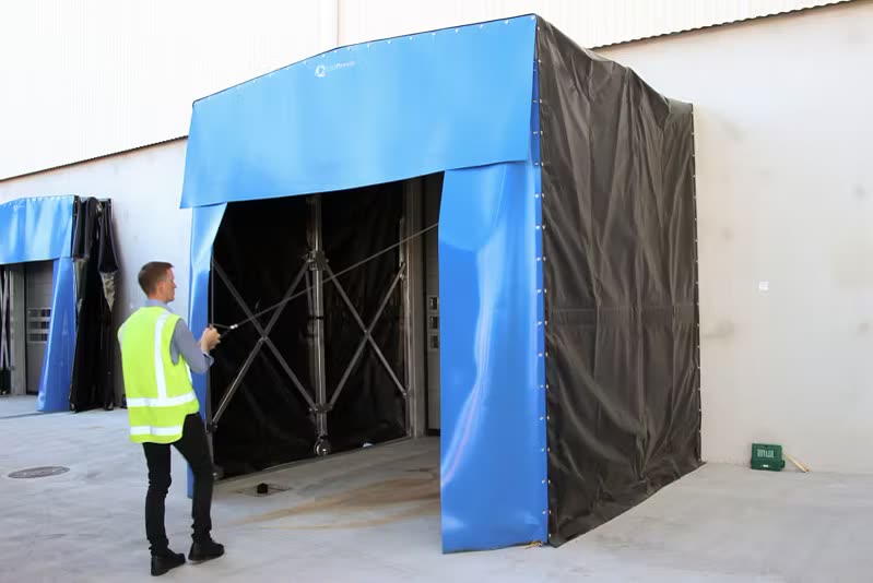 Flexible container shelter fitted to a warehouse loading bay with a trailer backed in