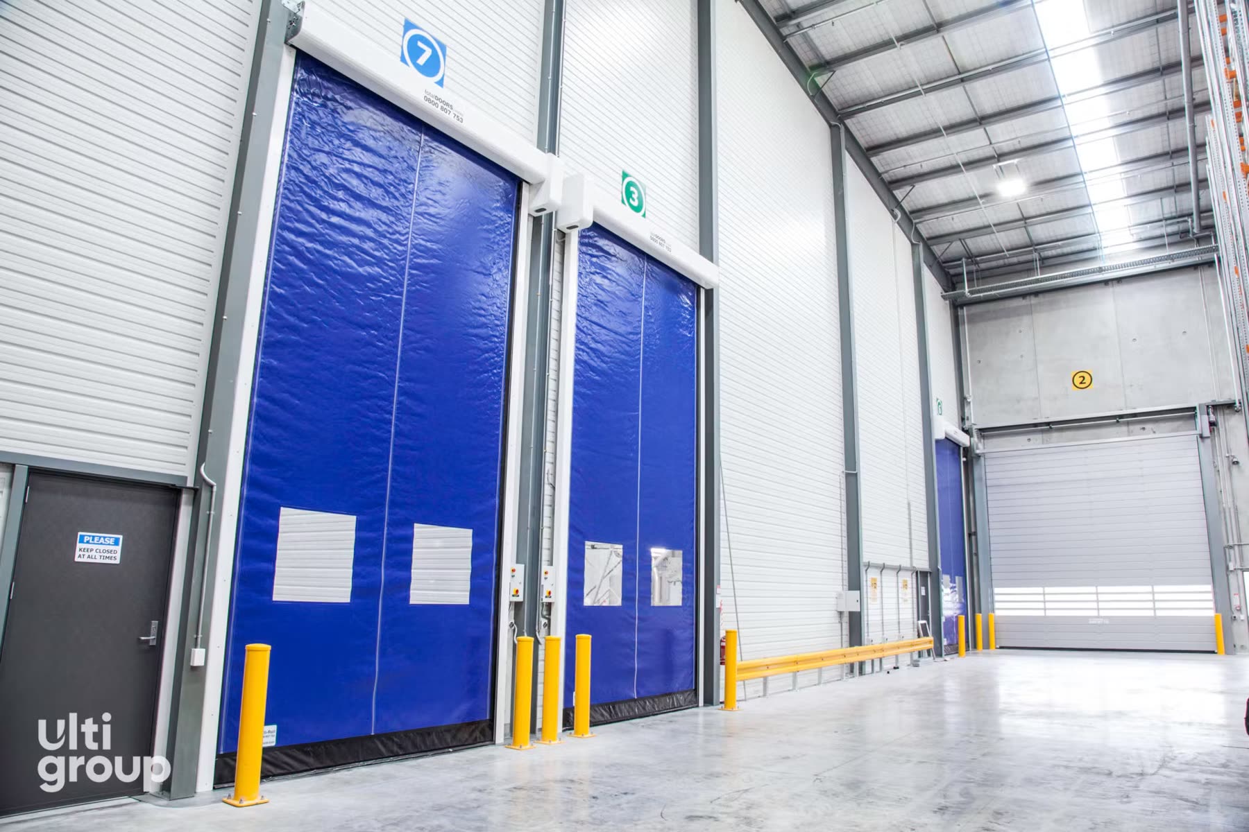 Insulated high-speed industrial door inside a cold storage facility with pallet racking alongside
