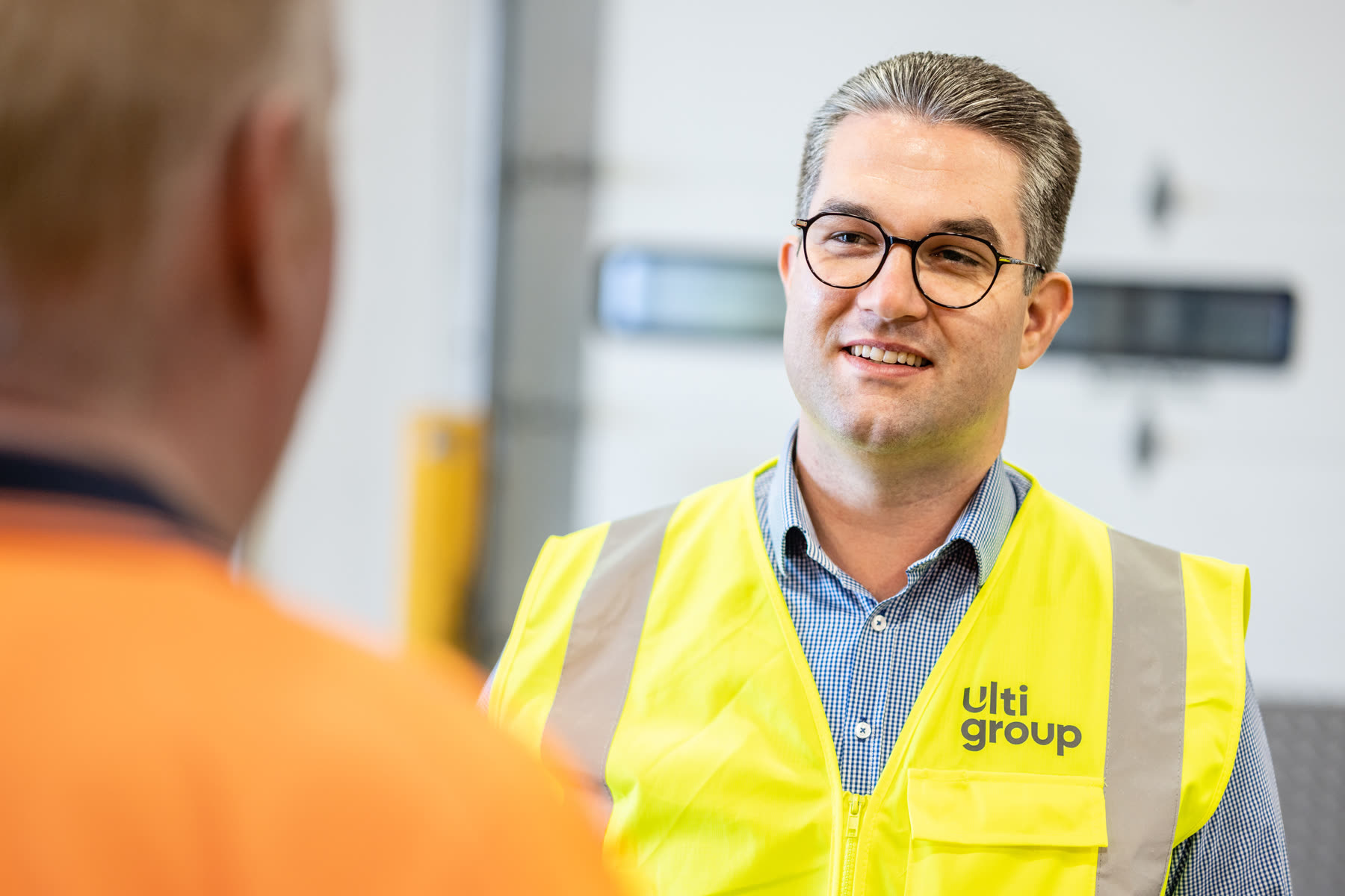 Two people in hi-vis reviewing an industrial door installation on site
